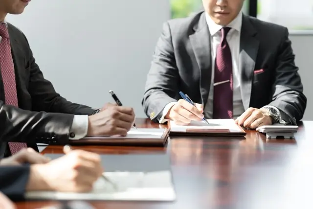 資料を見ながら資金繰りや返済予定を話し合うイメージ写真
